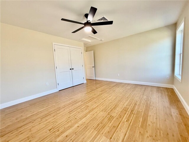 unfurnished bedroom with light hardwood / wood-style flooring, a closet, and ceiling fan