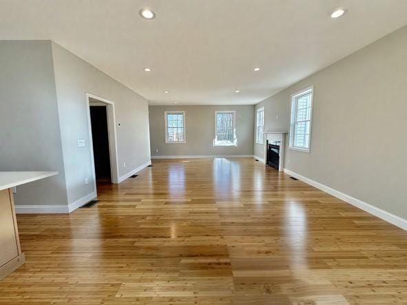 unfurnished living room featuring a healthy amount of sunlight and light hardwood / wood-style flooring