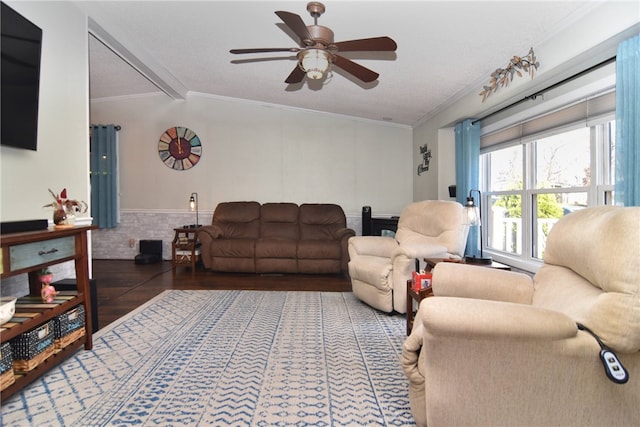 living room featuring lofted ceiling with beams, dark hardwood / wood-style floors, ceiling fan, and ornamental molding