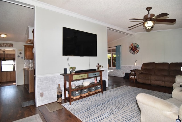 living room with a textured ceiling, dark hardwood / wood-style floors, ceiling fan, and ornamental molding