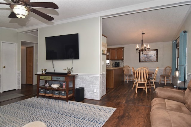 living room featuring a textured ceiling, ceiling fan with notable chandelier, dark hardwood / wood-style floors, and ornamental molding