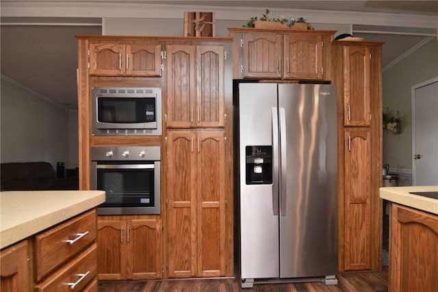 kitchen featuring dark hardwood / wood-style flooring, stainless steel appliances, and ornamental molding