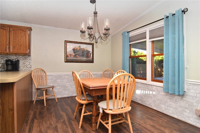 dining space featuring dark hardwood / wood-style flooring, crown molding, and a chandelier