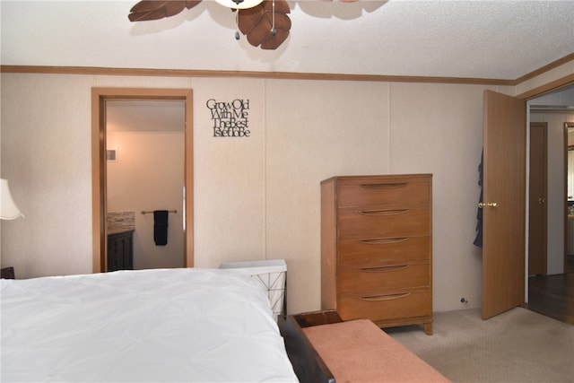 carpeted bedroom featuring a textured ceiling, ceiling fan, and ornamental molding