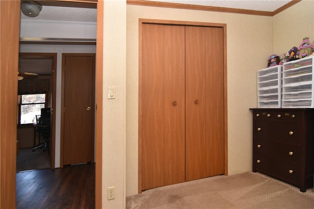 unfurnished bedroom with a textured ceiling, dark hardwood / wood-style floors, a closet, and ornamental molding