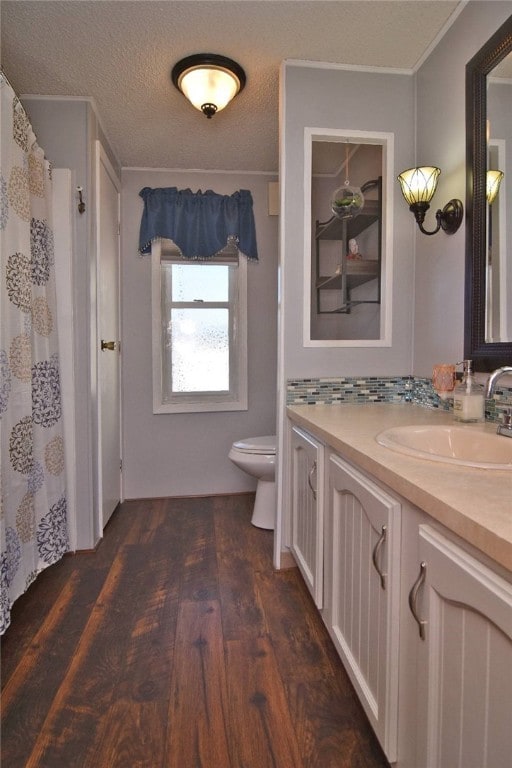 bathroom featuring hardwood / wood-style flooring, vanity, toilet, and a textured ceiling