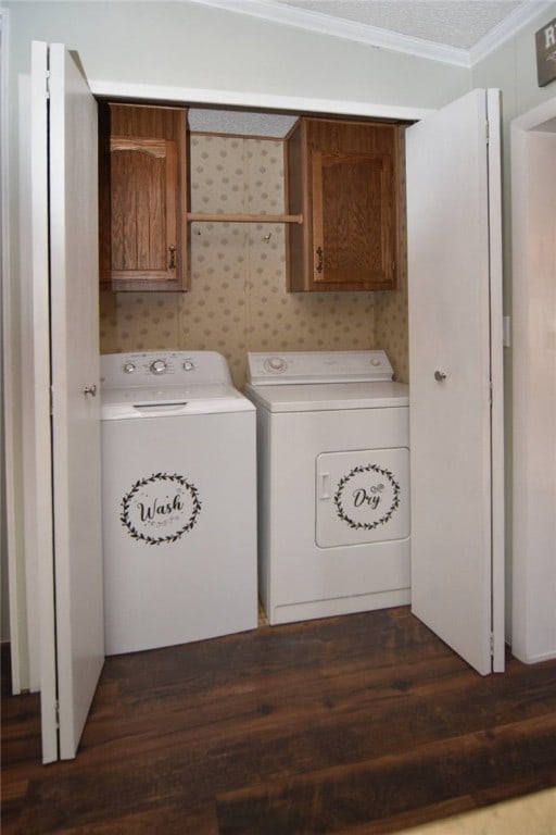 clothes washing area featuring cabinets, ornamental molding, separate washer and dryer, and dark wood-type flooring