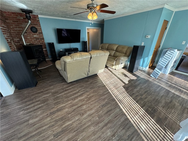 living room featuring ceiling fan, dark hardwood / wood-style flooring, a wood stove, and crown molding