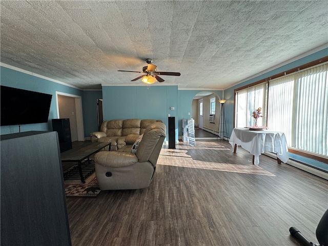 living room with dark hardwood / wood-style flooring, ornamental molding, a textured ceiling, baseboard heating, and ceiling fan