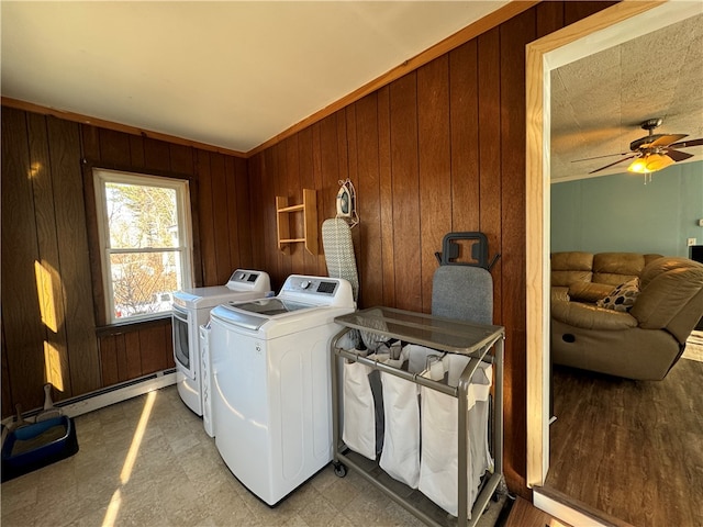 washroom with ceiling fan, wood walls, independent washer and dryer, and a baseboard radiator