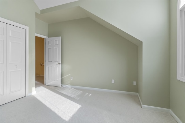 additional living space featuring lofted ceiling and light carpet