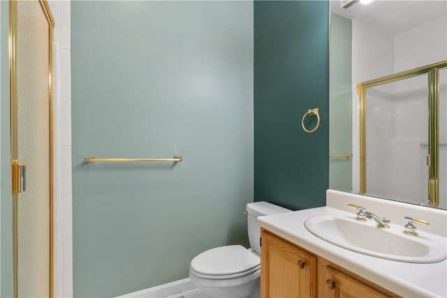 bathroom with vanity, toilet, and a shower with shower door