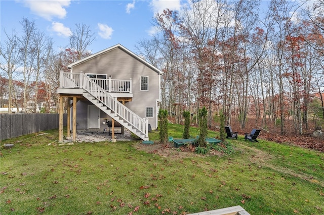 back of property featuring a lawn and a wooden deck