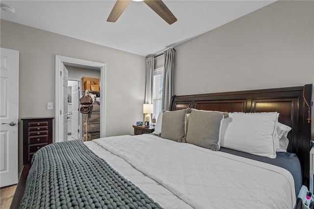 bedroom featuring hardwood / wood-style flooring, ceiling fan, and a spacious closet