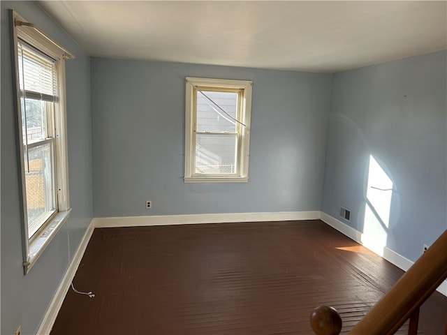 unfurnished room with dark wood-type flooring