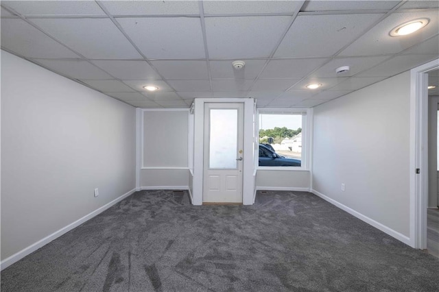 carpeted empty room featuring a paneled ceiling