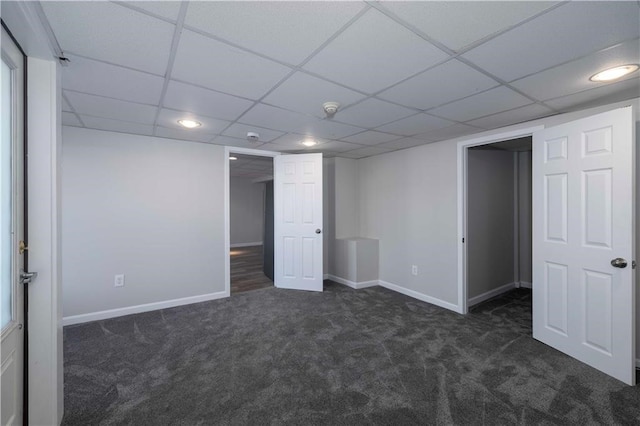 basement with dark colored carpet and a drop ceiling