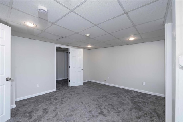 basement featuring a drop ceiling and dark carpet