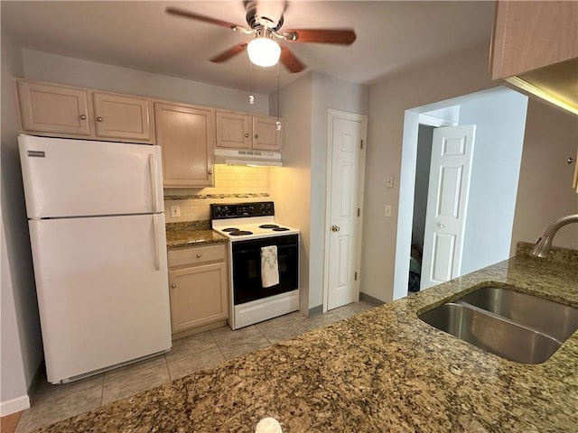 kitchen featuring white appliances, backsplash, dark stone counters, sink, and light brown cabinetry