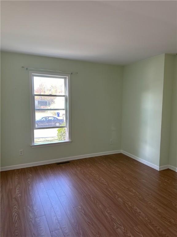 spare room featuring dark wood-type flooring