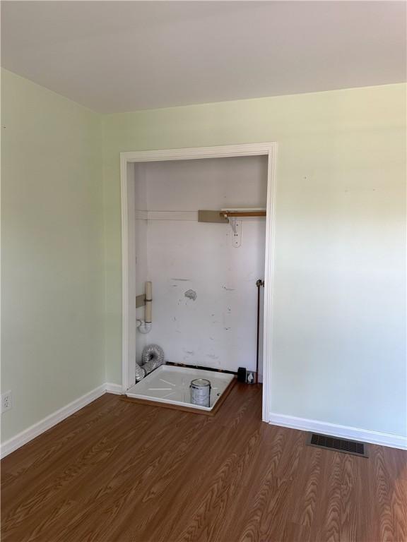 clothes washing area with dark wood-type flooring