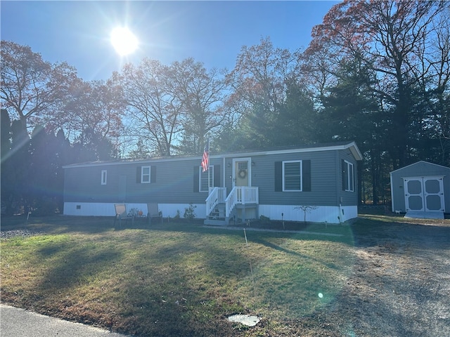 manufactured / mobile home featuring a storage unit and a front lawn