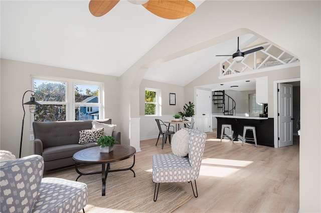 living room with ceiling fan, light hardwood / wood-style floors, and high vaulted ceiling