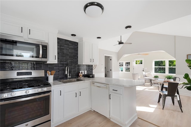 kitchen with kitchen peninsula, white cabinetry, and stainless steel appliances