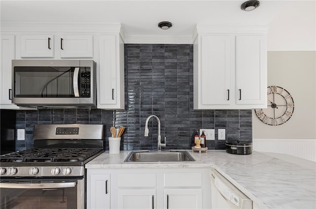 kitchen with crown molding, sink, appliances with stainless steel finishes, tasteful backsplash, and white cabinetry