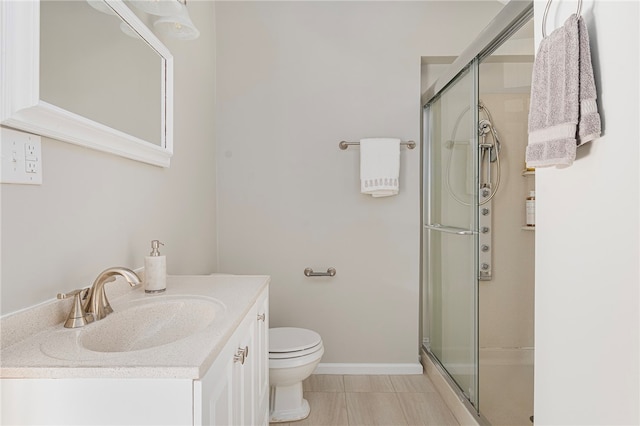 bathroom with tile patterned floors, vanity, toilet, and walk in shower