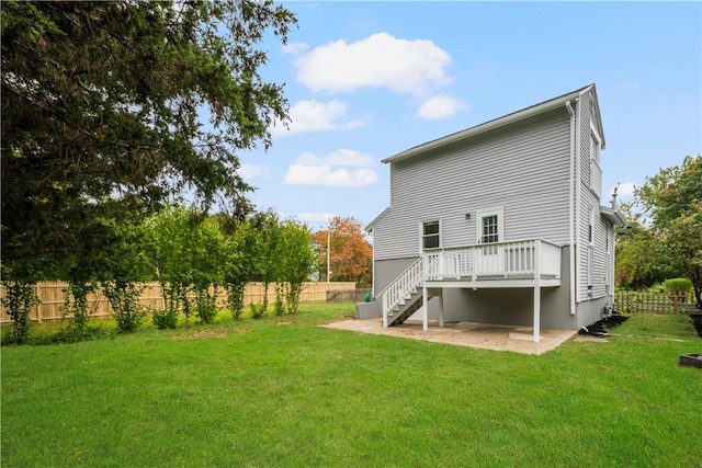 rear view of property featuring a patio, a deck, and a lawn