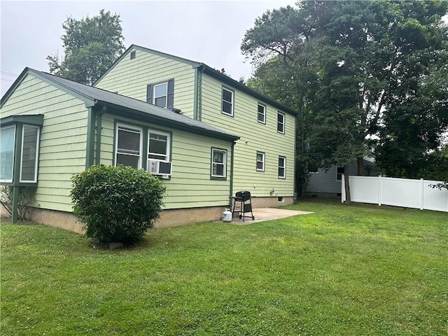 rear view of house with a lawn, cooling unit, and a patio area