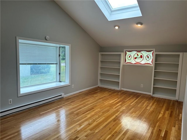 interior space with vaulted ceiling with skylight, light hardwood / wood-style flooring, and a baseboard radiator