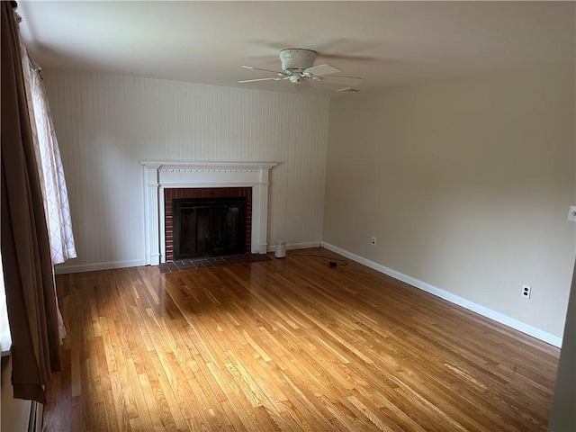 unfurnished living room featuring a fireplace, hardwood / wood-style floors, and ceiling fan