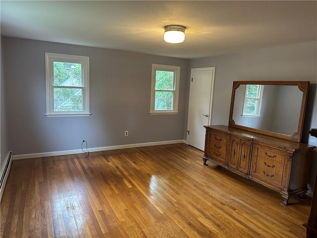 unfurnished bedroom featuring multiple windows and light hardwood / wood-style floors