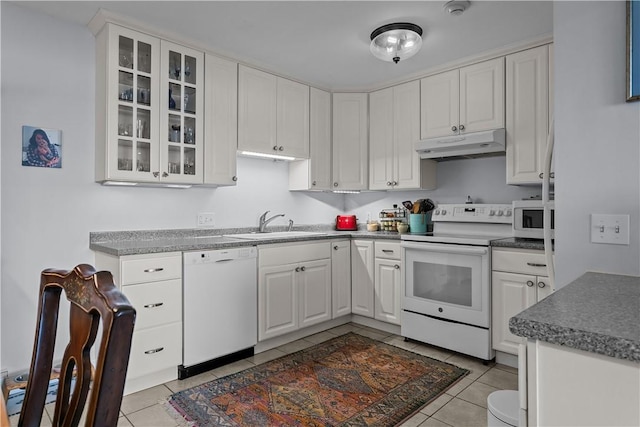 kitchen featuring light tile patterned floors, sink, white appliances, and white cabinets