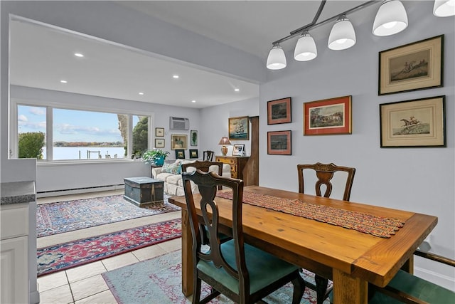 tiled dining room with track lighting, a wall mounted AC, a water view, and a baseboard radiator