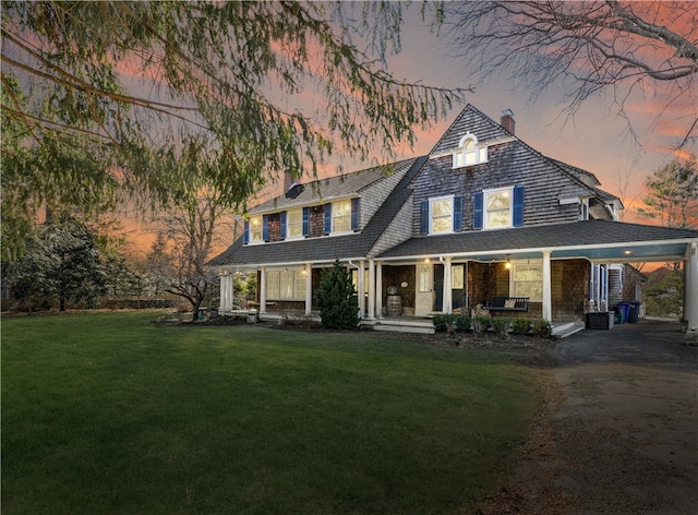 view of front of property with covered porch and a yard