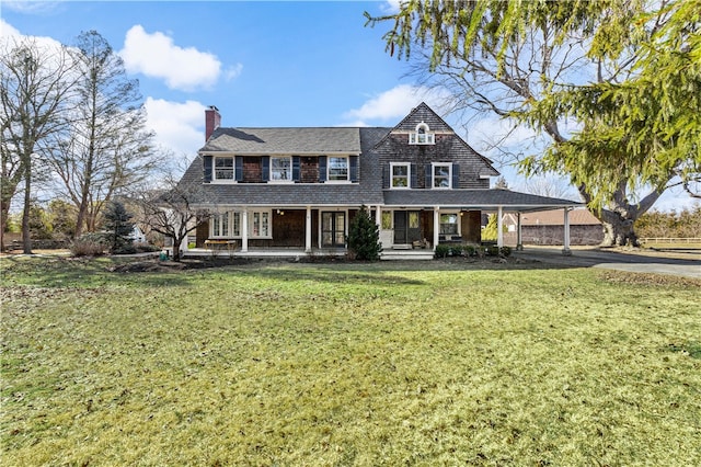 view of front of house with a front lawn, a porch, and a carport