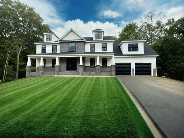 12 Beechwood Dr, Cranston, RI 02921 - view of front of home with driveway, a garage, a porch, a front lawn, and stone siding