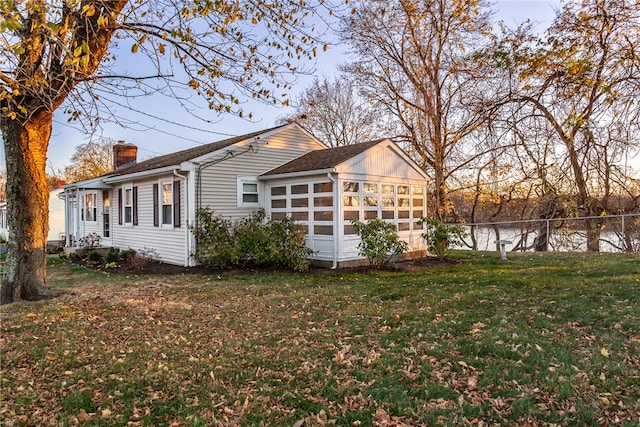 view of home's exterior featuring a sunroom and a lawn