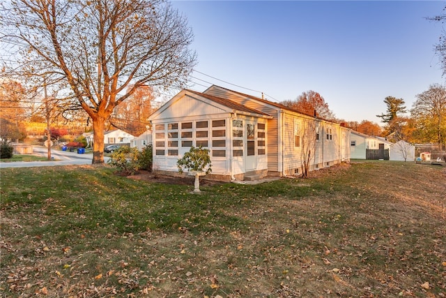 view of side of home with a yard and a sunroom