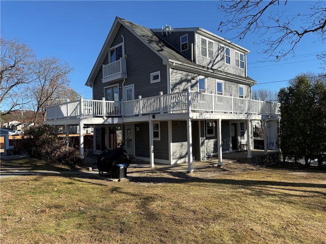 rear view of house featuring a yard and a deck