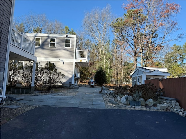 view of side of property featuring a balcony and a patio area