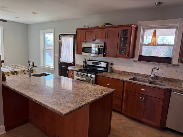 kitchen with plenty of natural light, sink, decorative backsplash, and stainless steel appliances