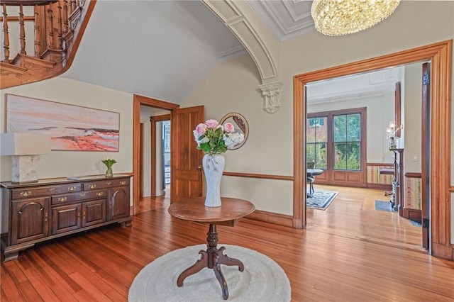 entrance foyer featuring a chandelier, crown molding, and light hardwood / wood-style flooring