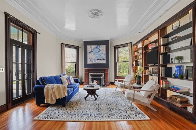 sitting room with a fireplace, hardwood / wood-style floors, and crown molding