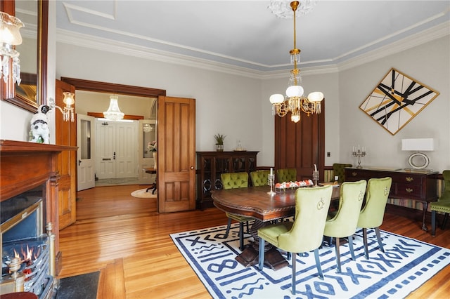 dining space featuring a chandelier, wood-type flooring, and ornamental molding