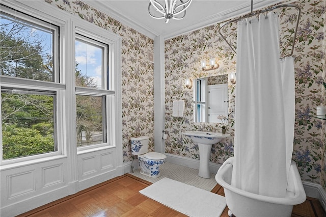 bathroom featuring a chandelier, a tub to relax in, crown molding, and parquet flooring