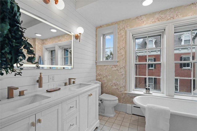 43 Old Beach Rd, Newport, RI 02840 - bathroom with tile patterned floors, wallpapered walls, a freestanding tub, toilet, and double vanity